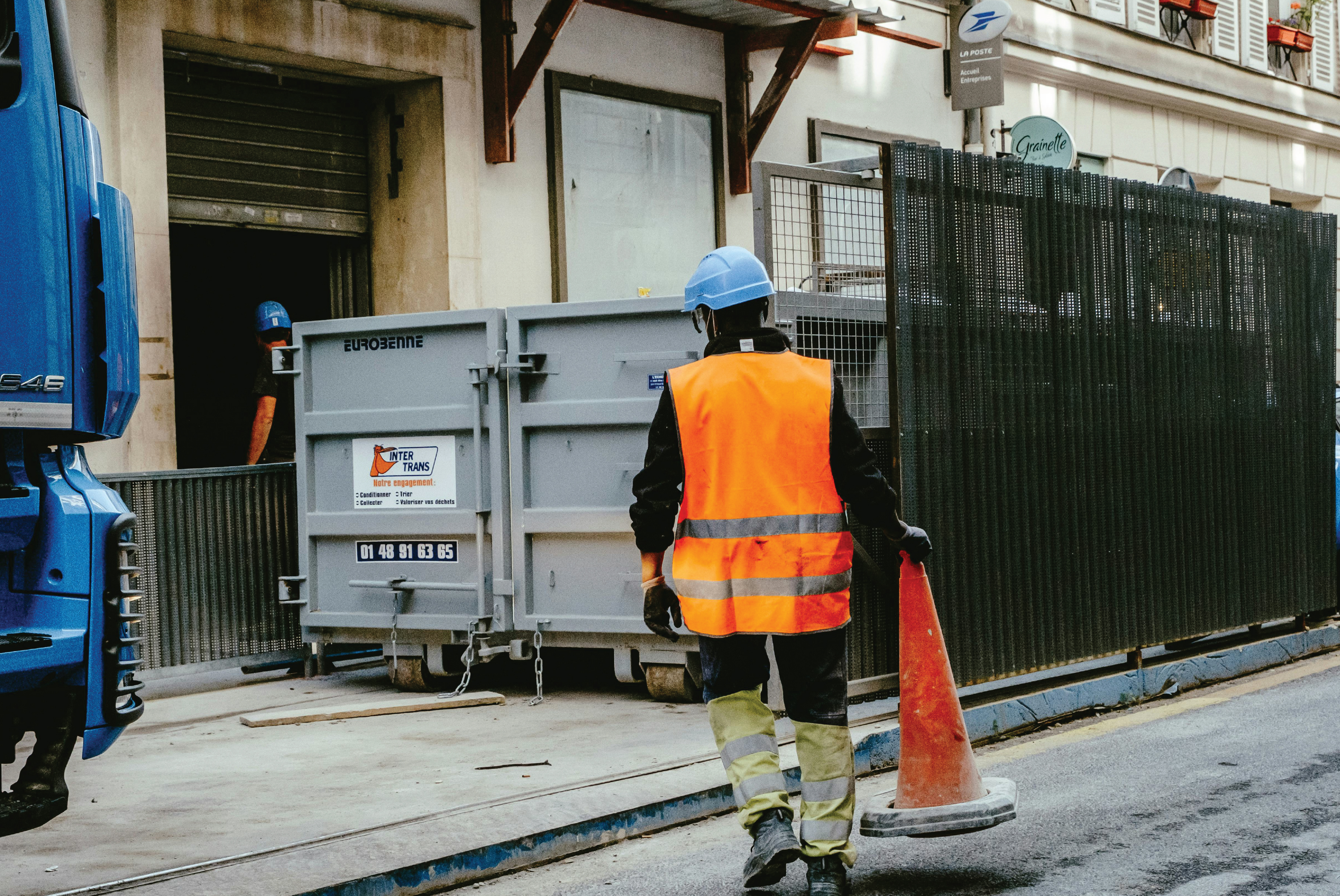 Construction worker moving caution cone
